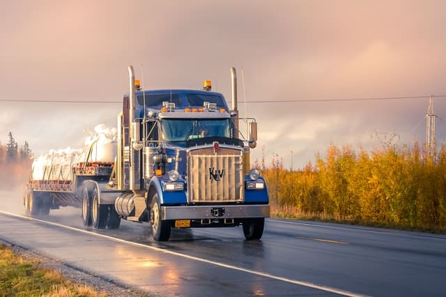 A blue truck driving on the road.