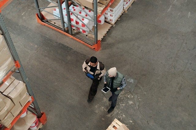 Two men checking inventory in a warehouse.