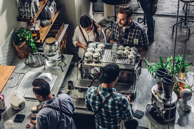 A man and a woman buying coffee at a coffee shop.