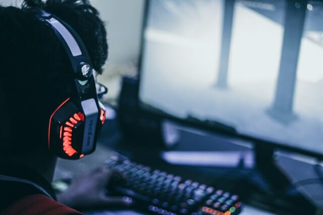 A person with headphones playing video games